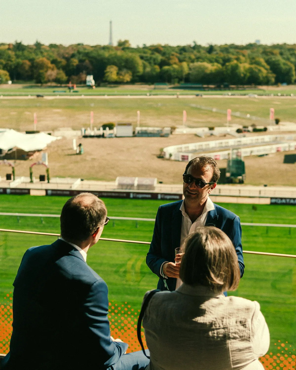 Une conversation entre invités, face à l’hippodrome de Longchamp